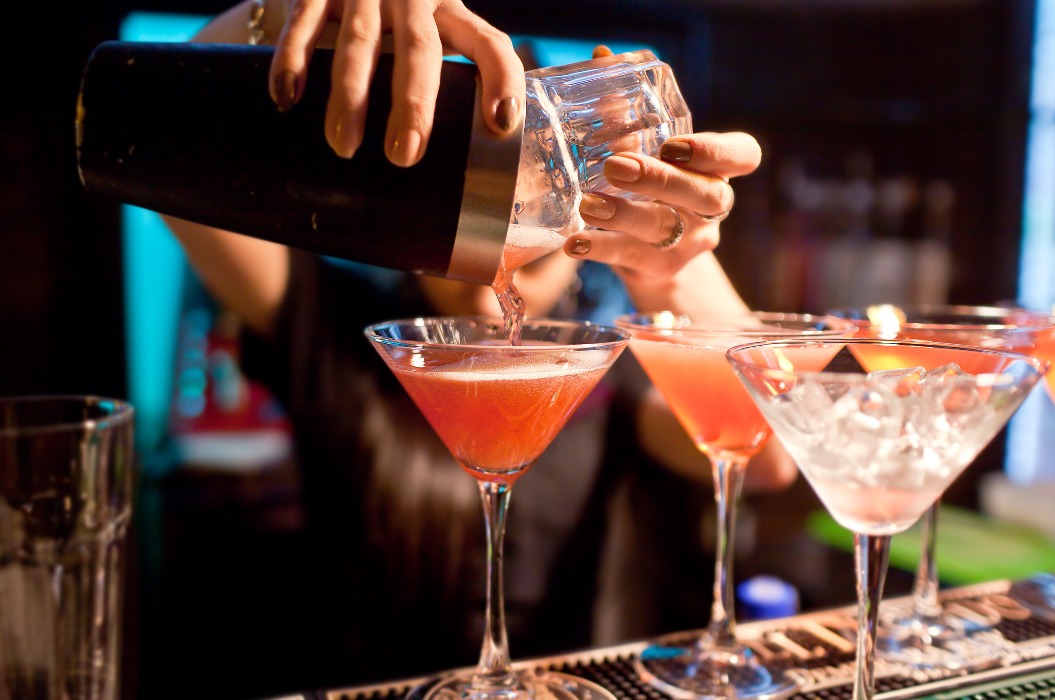 Die Barkeeperin mixt im Nachtclub einen Cocktail